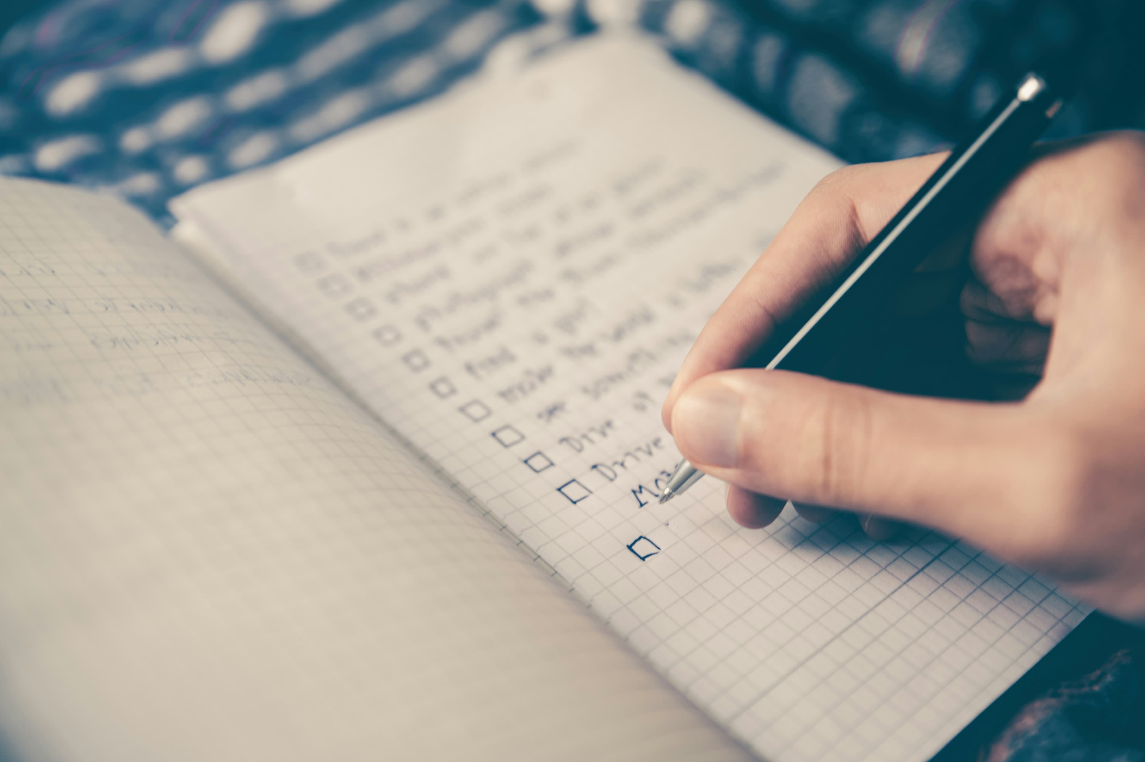 Person using a pen to write their goals